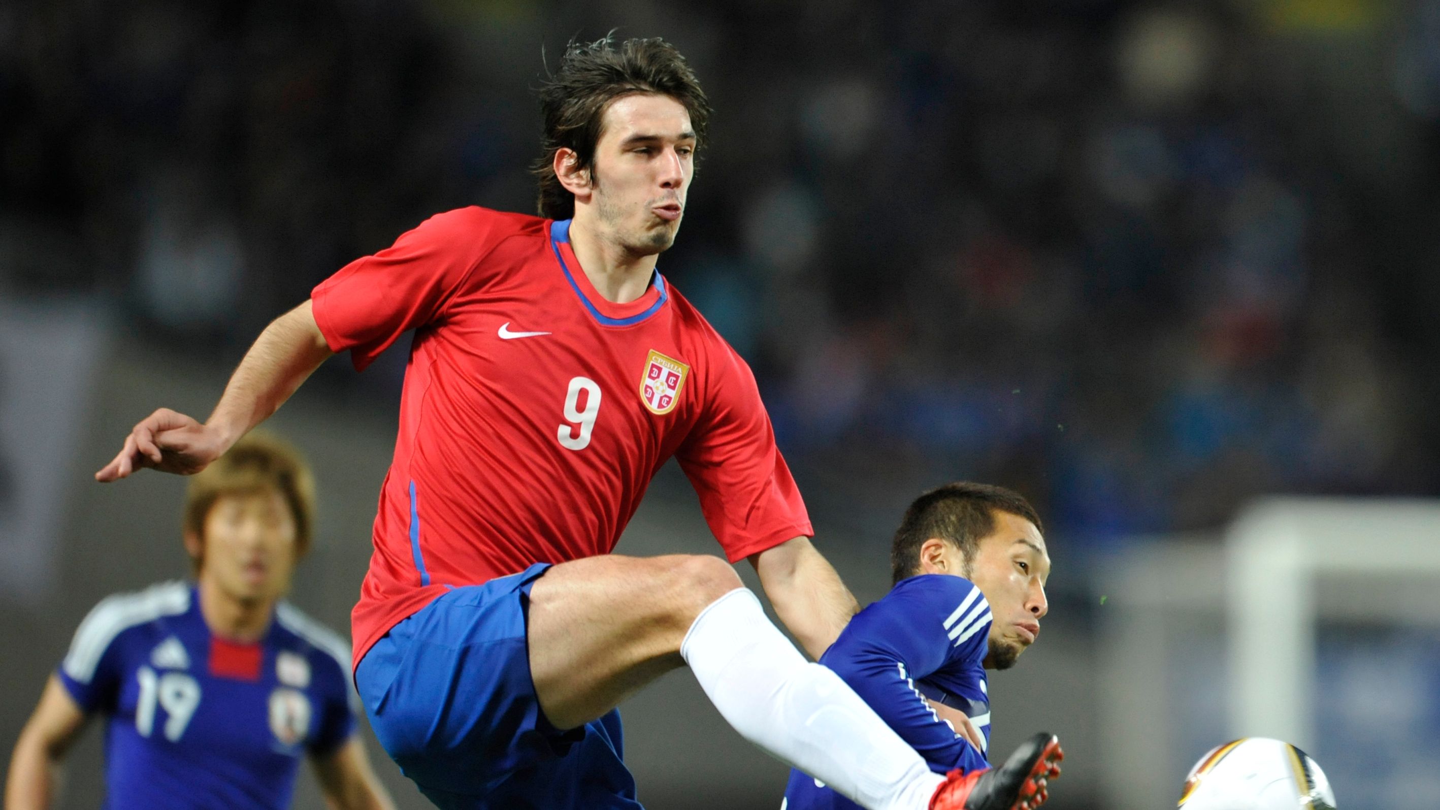 Serbia's forward Dejan Lekic (C) vies fo