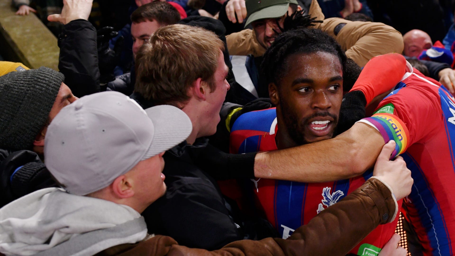  Jeffrey Schlupp celebrates scoring a spectacular goal against Manchester City, as ecstatic Crystal Palace fans erupt in joy in the background.
