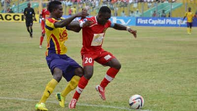 Amos Frimpong of Asante Kotoko holds of Hearts of Oak defender