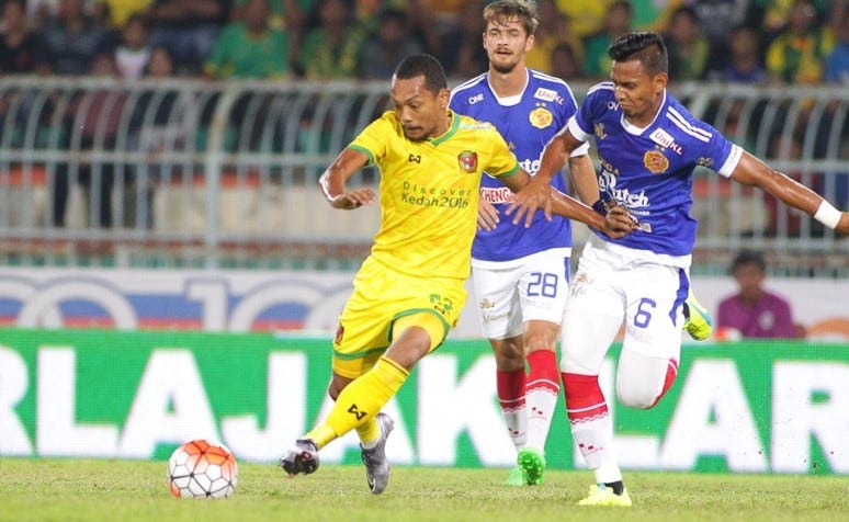 Kelantan's Farisham Ismail (right) and Jonatan Lucca (middle) tussle for the ball with Kedah's Syazwan Zainon
