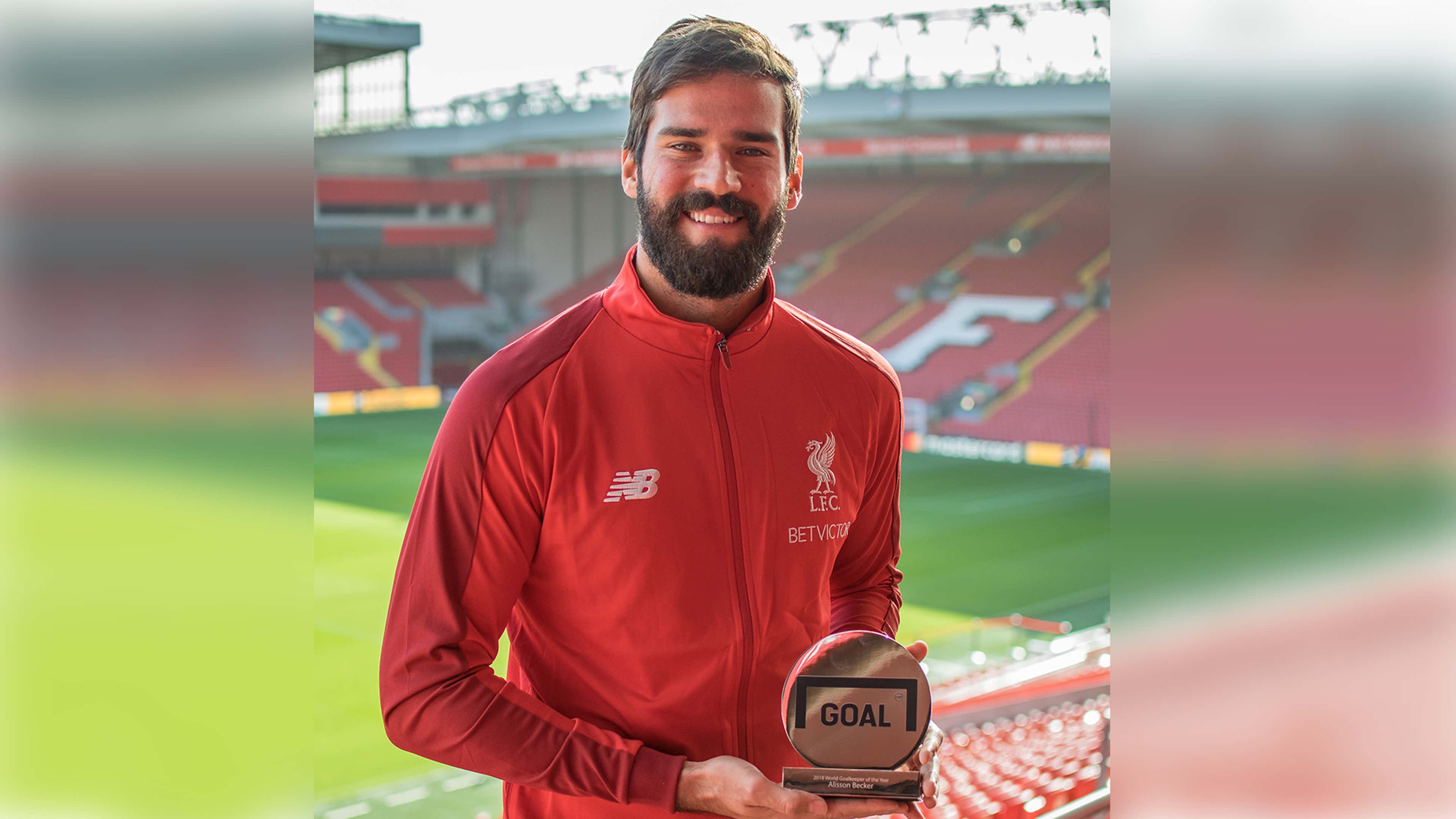 Liverpool's Alisson collecting his Goalkeeper of the Year trophy from Goal