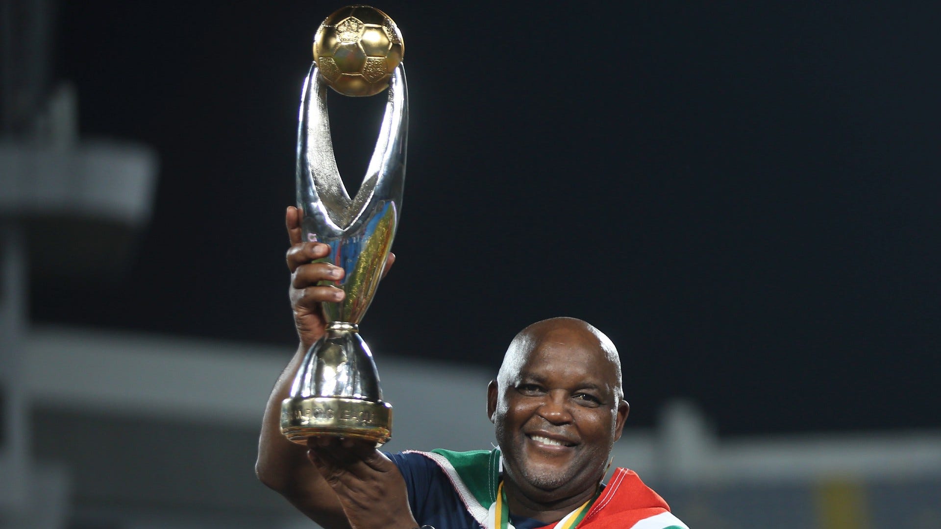 Pitso Mosimane, coach of Al Ahly holds trophy
