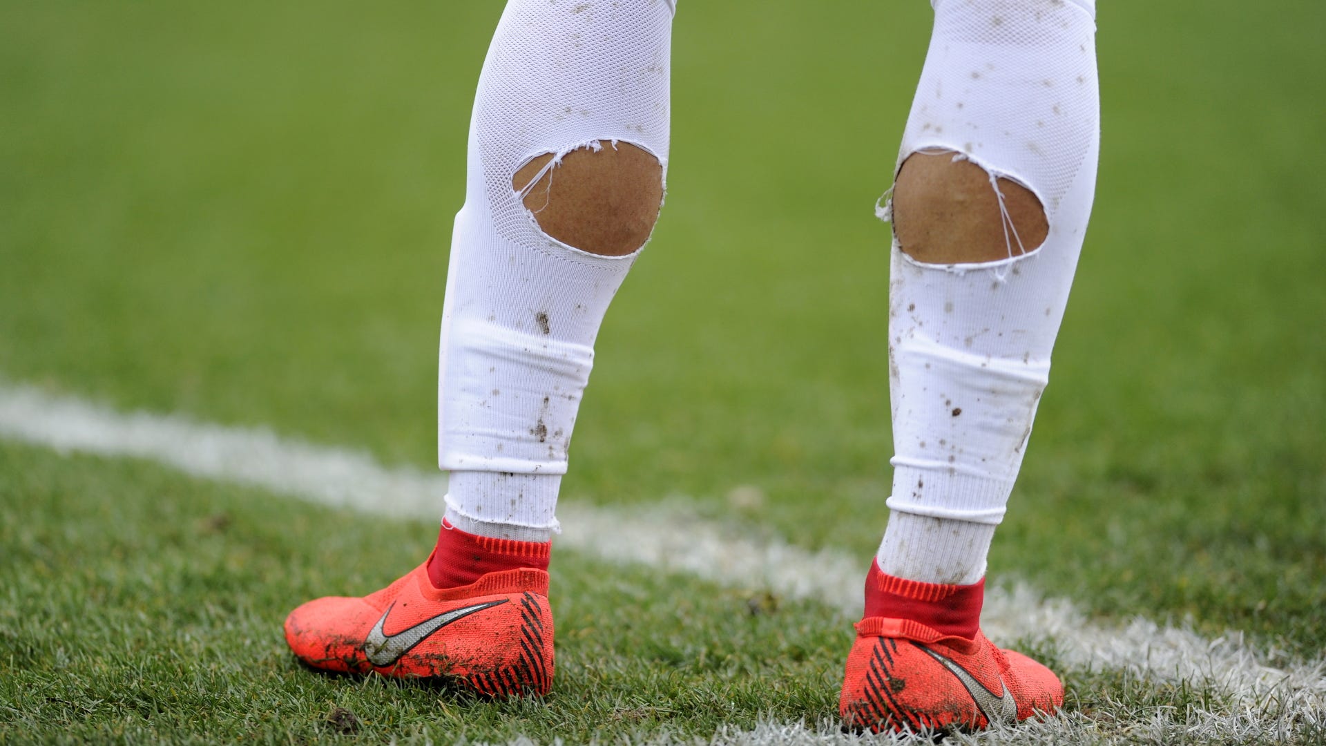 Explained: Why do footballers cut holes in their socks? | Goal.com US