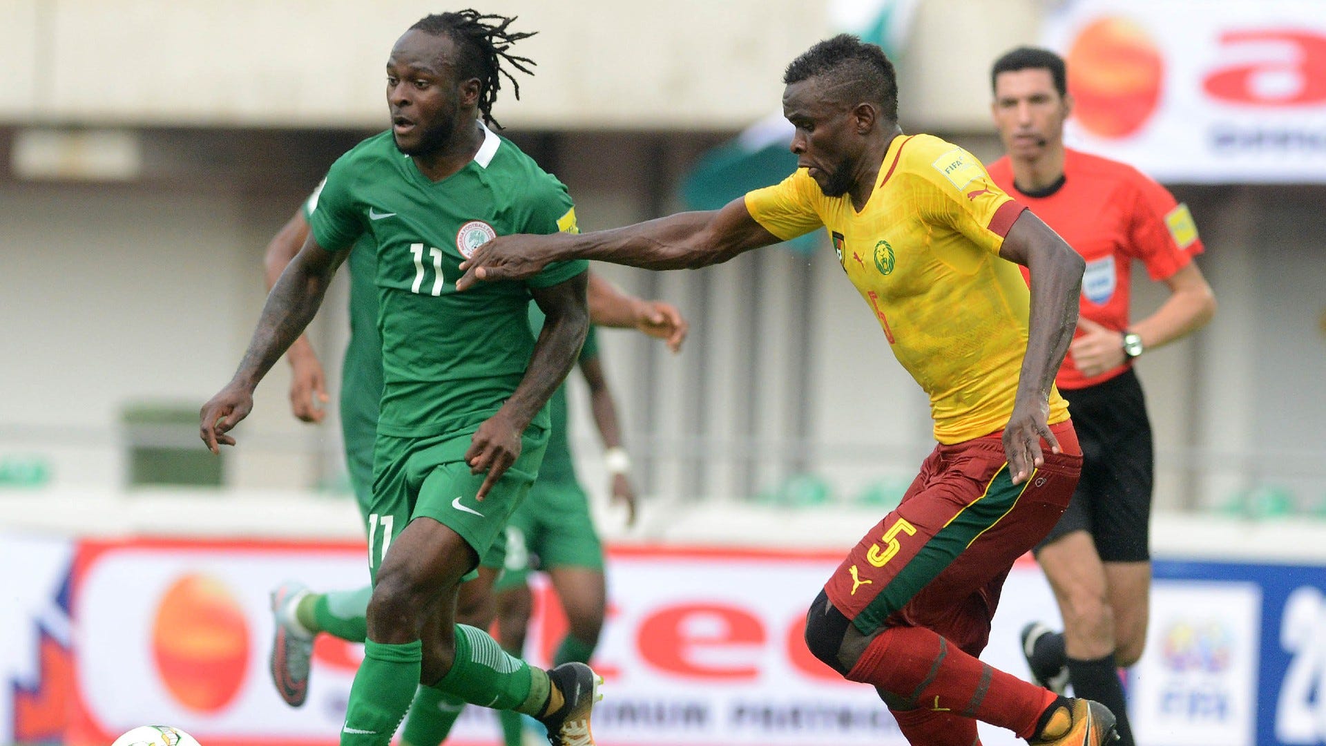 Victor Moses of Nigeria shield the ball away from Ngadeu Ngadjui of Cameroon.
